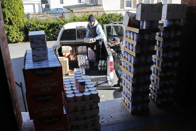 New Bedford police dispatcher, Zyre Andrade, and his father State Police officer Chris Andrade, of PAPA (Portuguese American Police Association) donate to the Immigrants Assistance Center in New Bedford enough food items to make two hundred Thanksgiving day meals.  These items were purchased with money which PAPA generated in fundraisers throughout the year and assistance from the Walmart in Dartmouth.  PHOTO PETER PEREIRA