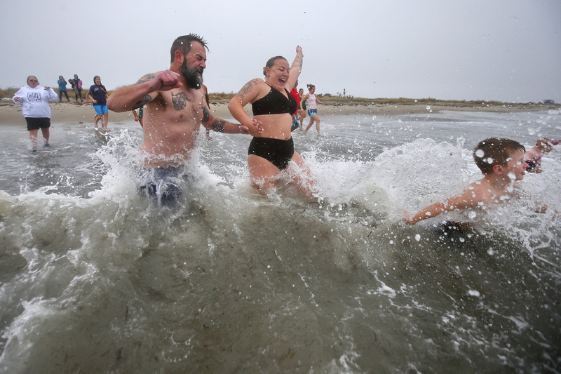 James O'Driscoll, brother of Shannon, and wife Sarah O'Driscoll jump into the cold waters off Gooseberry Island in Westport, MA during the annual Plunge of the Faithful. The event is a fundraiser held in memory of Shannon O'Driscoll, 24, who was killed November 2006 when she was struck by an SUV in Plainville, MA while holding a sign supporting state daycare centers.  PHOTO PETER PEREIRA