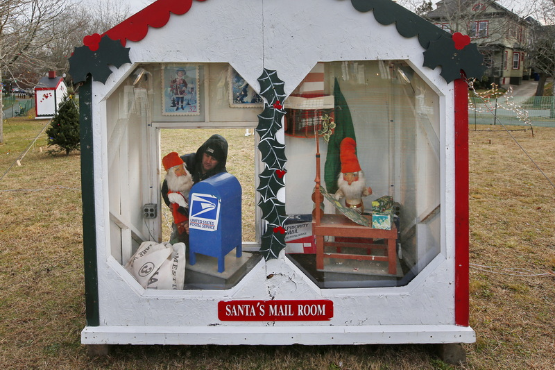 Greater New Bedford Regional Vocational Technical High School electrical instructor, Jeremy Carreiro, finds himself inside of Santa's Mail Room as he makes adjustments to the wiring inside one of the many animated Christmas houses at the Clasky Common Park in New Bedford.  The park and its lights will open next Sunday and will turn on every night at 5pm. PHOTO PETER PEREIRA