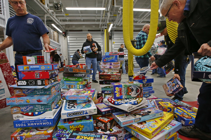 New Bedford firefighters sort through the thousands of toys collected during the 25th Annual United Way of Greater New Bedford and New Bedford Firefighters' Union Toy Drive at the Public Safety Center on Brock Avenue in New Bedford, MA.  PHOTO PETER PEREIRA