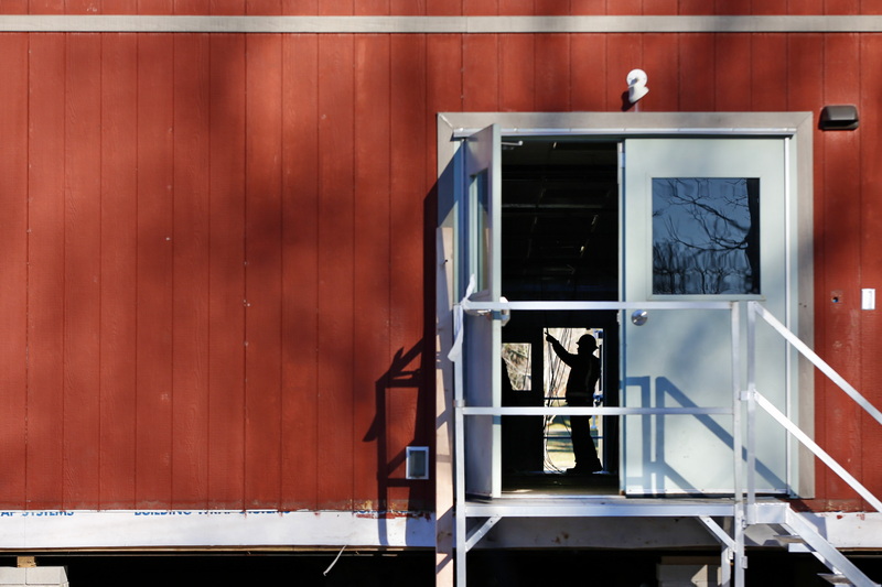 A worker is seen through the open door of the temporary trailers being installed at Umass Dartmouth to house professors and students during renovations to the Group 1 building in Dartmouth, MA.  PHOTO PETER PEREIRA