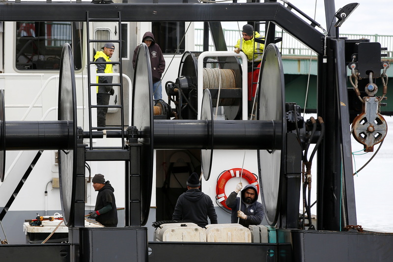 Fishermen aboard the fishing boat Ocean Queen are seen through various gaps in the stern of the fishing boat docked in New Bedford, MA.  PHOTO PETER PEREIRA