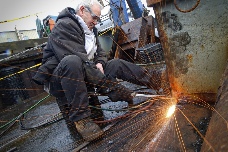 Zeca DeMello sends sparks flying as he cuts the existing deck of the fishing boat Mary Anne, before installing new decking on the boat undergoing extensive repairs in New Bedford, MA. PHOTO PETER PEREIRA