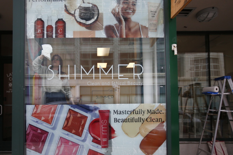 Katherine Lowe, owner of Shimmer on Union Street in downtown New Bedford, gives the front windows of her store a cleaning in preparation to be featured on the TV show Chronicle which is featuring her store for the humanely sourced products she sells. PHOTO PETER PEREIRA