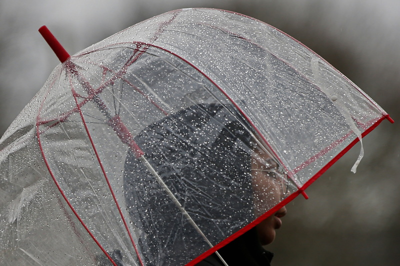 A woman walks down Wing Street in New Bedford, MA under the cover of a clear umbrella on a rainy morning. PHOTO PETER PEREIRA