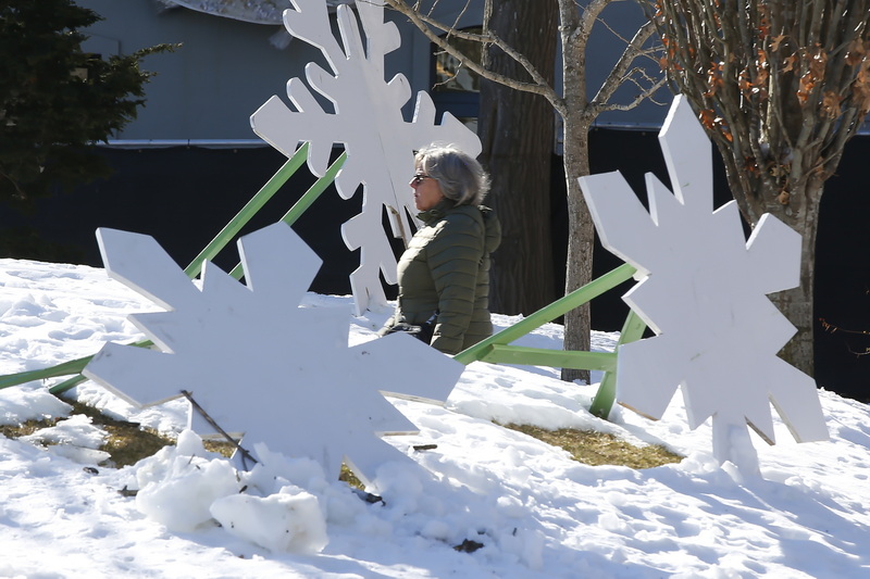 A woman makes her way across Custom House Square in New Bedford, MA past three snow flake sculptures. PHOTO PETER PEREIRA