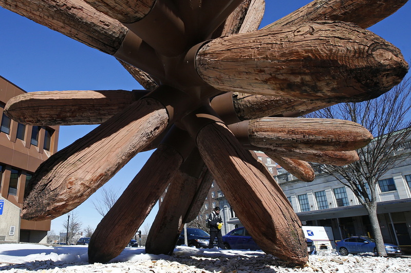 A man walks past the iconic sea urchin sculpture in front of the Federal building in downtown New Bedford, MA. PHOTO PETER PEREIRA