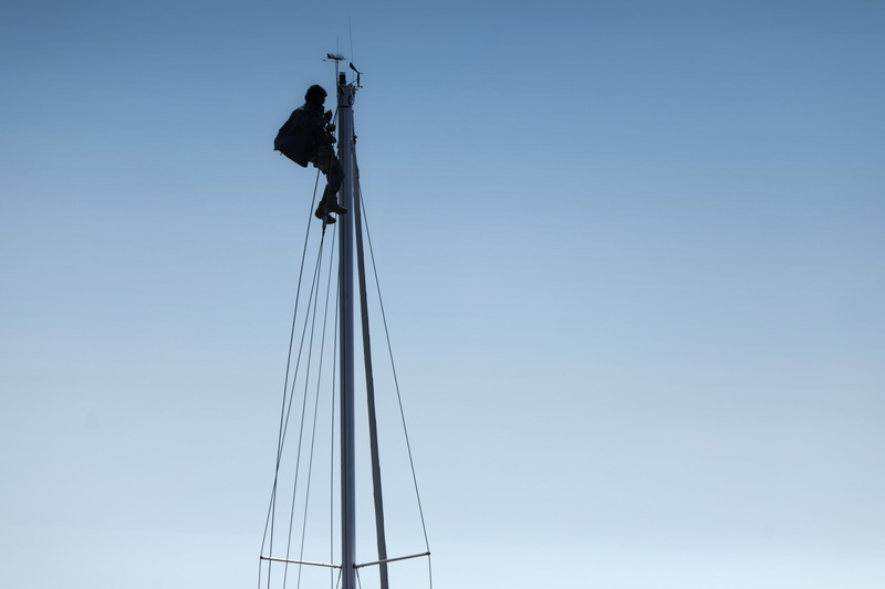 A rigger finds himself high above Mattapoisett harbor making repairs to the mast of a sailboat recently put in the water.