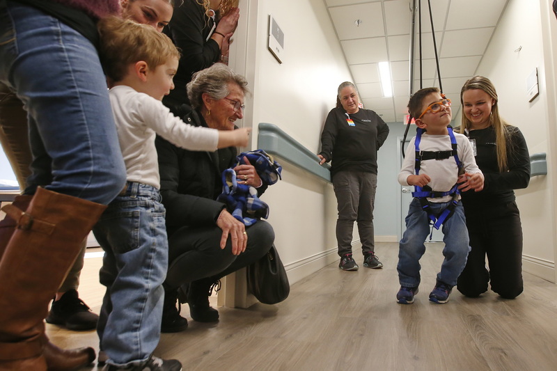 Austin Carrita, 2, points at his brother Grayson Ferreira, 6, who was diagnosed with cerebral palsy at birth, as he walks alone with the assistance of a suspension system installed at the new Southcoast Health Pediatric Rehabilitation Program building on Acushnet Avenue in New Bedford, MA.  Next to him Erica Keisling, physical therapist, encourages Grayson to walk on his own. PHOTO PETER PEREIRA