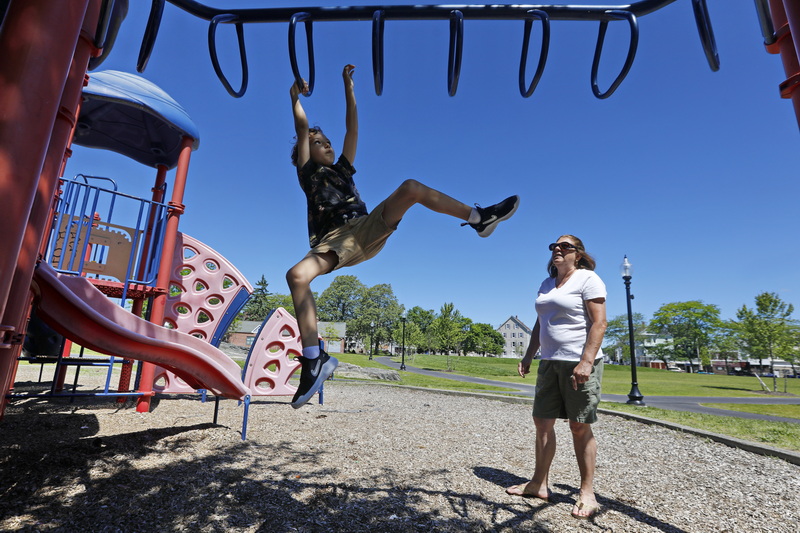 Ivone Dutra looks on as her great-nephew, Parker Griffin, 5, plays on the playground at Ashley Park in the Goulart Square area of New Bedford which has undergone a $1.7 Million renovation. PHOTO PETER PEREIRA