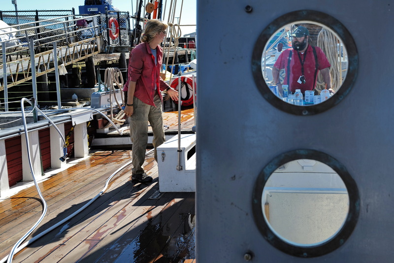 Capt. Billy Sabatini directs Lydia Dykema, deckhand, on which sections of the deck to wash during a routine maintenance session aboard the schooner Ernestina-Morrissey docked at State Pier in New Bedford, MA. PHOTO PETER PEREIRA