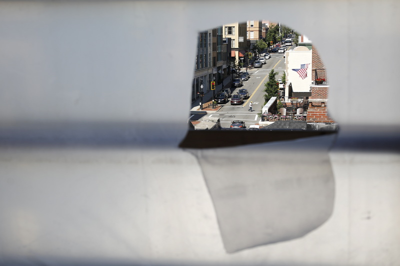 A man walks across Union Street in downtown New Bedford, MA as seen through a gap in the temporary covering in one of the windows of the apartment complex being constructed at intersection of N Second Street. PHOTO PETER PEREIRA