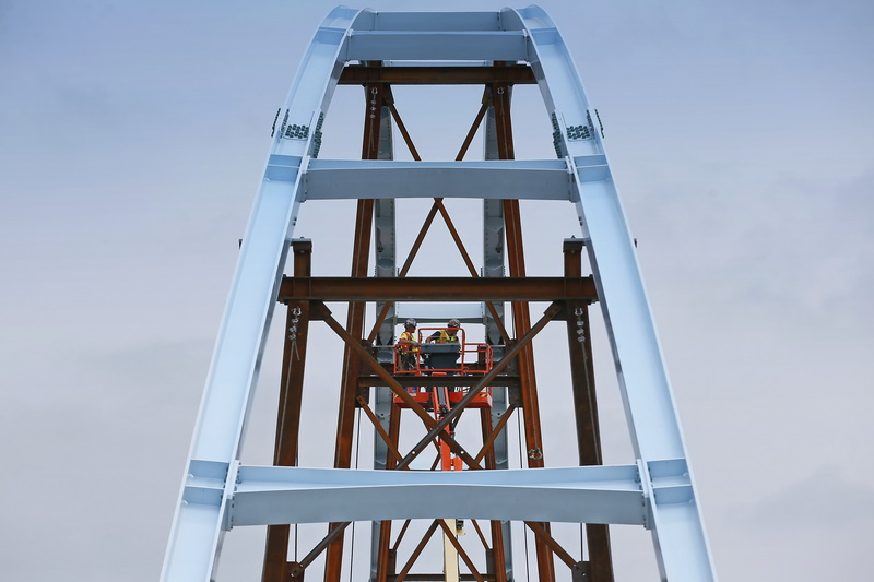 Iron workers torque the bolts creating the arches for the new pedestrian bridge being constructed over Route 18 in New Bedford, MA. PHOTO PETER PEREIRA