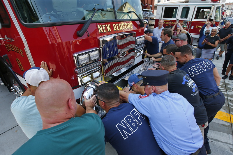 New Bedford firefighters push the new Engine 8 fire apparatus into the garage as part of a ceremony steeped in tradition.  The new $750,000 fire truck replaces the 16-year-old previous Engine 8, seen in background, at Station 8 on Acushnet Avenue in New Bedford, MA.  PHOTO PETER PEREIRA