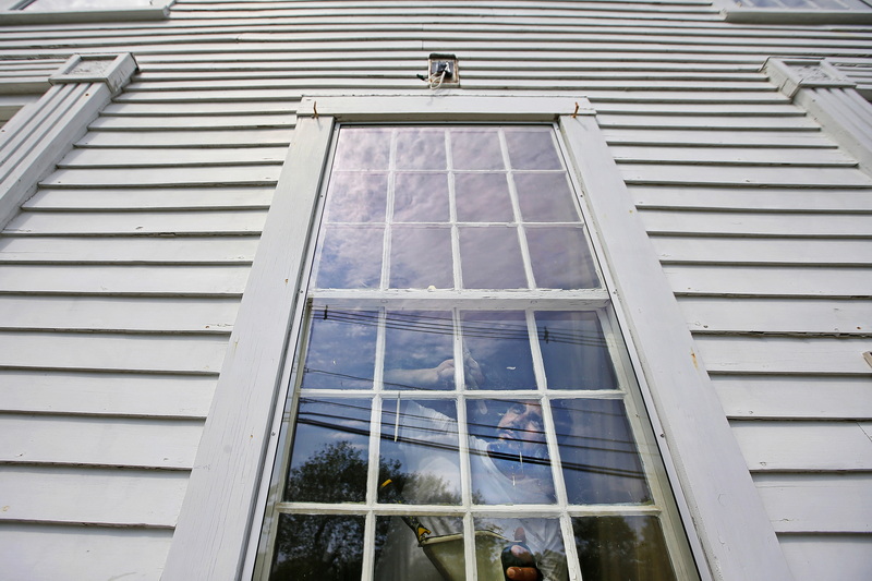 Elias Alves-Sobrinho of R. P. Valois paints the window trims of the new Westport Historical Society building at the former Bell School House in Westport, MA.  PHOTO PETER PEREIRA