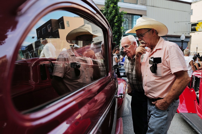 Two men take a closer look at one of the many vintage cars on display at the annual Joe Jesus' 50s Night in downtown New Bedford, MA.  PHOTO PETER PEREIRA