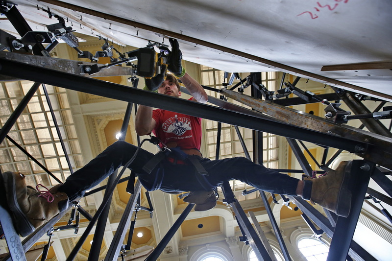 Nicholas Chrusten hangs between supporting beams as he constructs the walls of the soon to open Boulder Union climbing gym inside the former New Bedford Institute for Savings historic building on Union Street in downtown New Bedford, MA.  PHOTO PETER PEREIRA