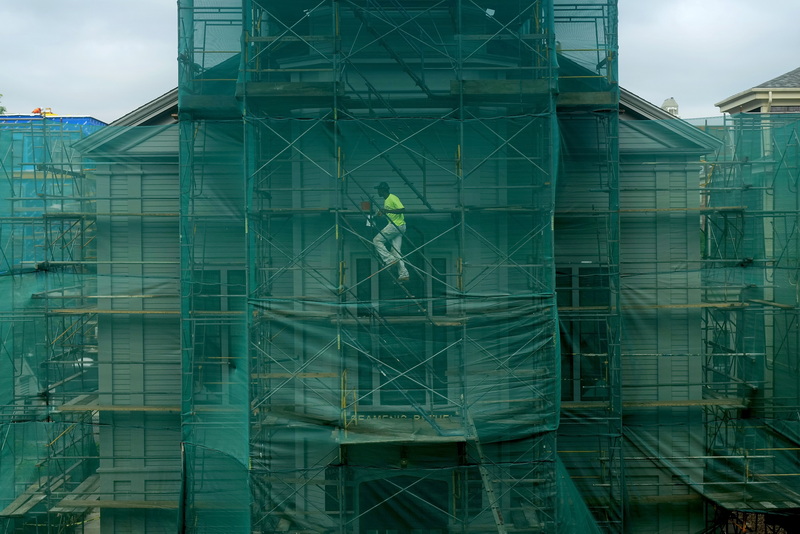 A JAG Painters worker makes his way up the staging in front of the Seamen's Bethel in downtown New Bedford, MA behind a protective green cover. PHOTO PETER PEREIRA