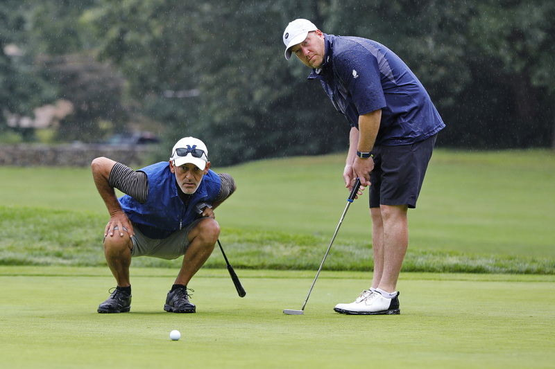 Paul Dias and Jon Ritter will the ball to the hole during a wet edition of the 94th Annual Four-Ball Tournament at The Country Club of New Bedford. PHOTO PETER PEREIRA