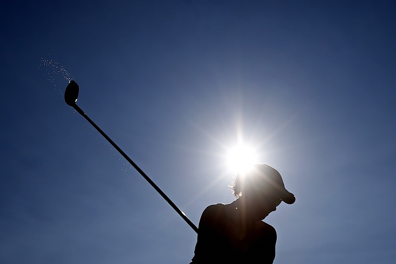 Water from a wet turf is seen on the club of Kim Walecka as she tees off at the Country Club of New Bedford 45th Women's Four-Ball Invitational.  PHOTO PETER PEREIRA