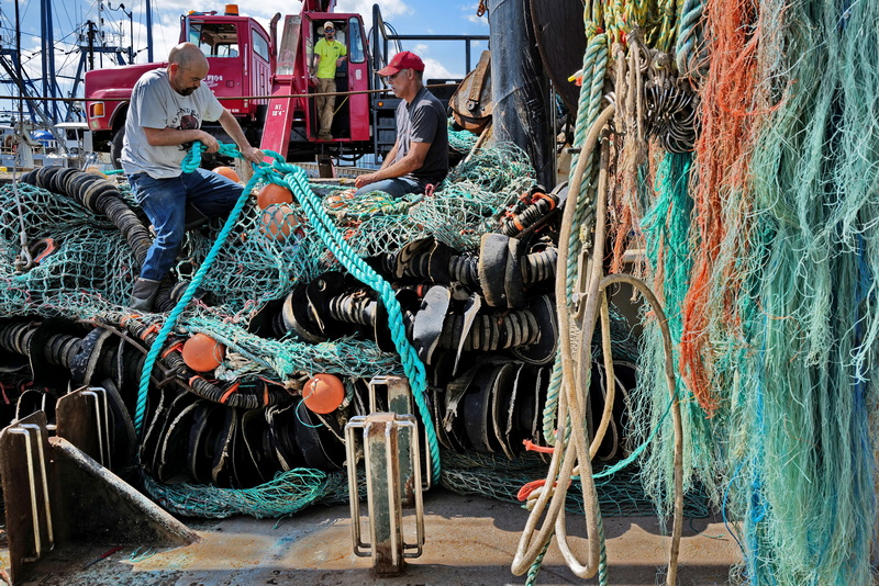 Captain Jay Spivey and  Otis Williams, Mate, prepare the ground fishing net to be removed for repairs from the fishing boat docked at State Pier in New Bedford, MA before a new one is put on board before heading back out to sea.  PHOTO PETER PEREIRA