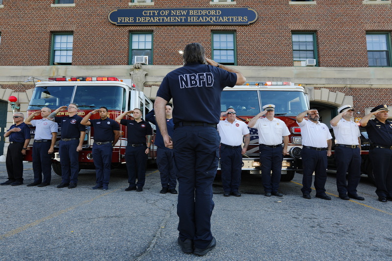 Firefighters stand at attention during a ceremony commemorating 9/11 victims held in front of the New Bedford Fire Department Headquarters.  PHOTO PETER PEREIRA