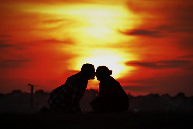 A couple kiss while sitting atop on outcrop at Fort Phoenix in Fairhaven, MA as the sun sets in the distance. PHOTO PETER PEREIRA