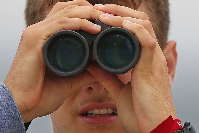 UMass Dartmouth biology student, Joel Eckerson, uses his binoculars to take advantage of the northwesterly winds to spot a variety of birds off of Gooseberry Island in Westport, MA. PHOTO PETER PEREIRA