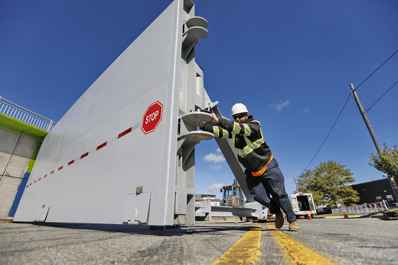 New Bedford DPI working foreman, Tyler Washburn, pushes the huge hurricane barrier doors of gate 2 on West Rodney French Boulevard in New Bedford, MA back into place after closing them in preparation for hurricane season. PHOTO PETER PEREIRA