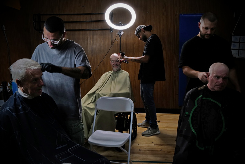 Keehan Arruda, Mission Barber Shop, Stevie Monteiro, Mission Barber Shop and Jared Rodrigues of The Spot Barber Lounge, volunteer their time to give Chris Dickinson, Liam McBrien and Ray Morin haircuts at the annual New Bedford Connect RiseUpForHomes.com conference held in the New Bedford YMCA with various resources and services for individuals for families who are unhoused or are at risk. PHOTO PETER PEREIRA