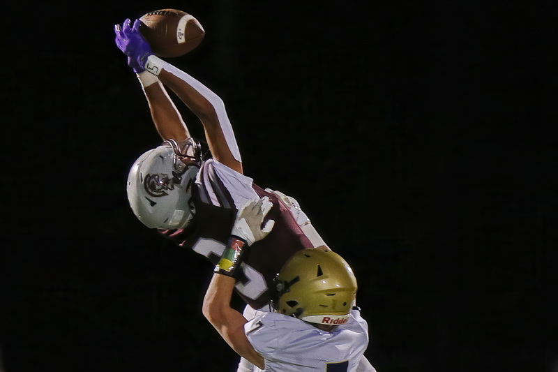 Stang wide receiver Try Gonsalves Cosme elevates for the catch as Archbishop Williams' Devin Sheehan makes the defensive play during Bishop Stang High School's win at home against Archbishop Williams High School in Dartmouth, MA. PHOTO PETER PEREIRA