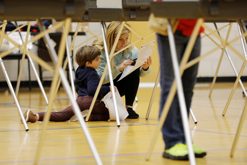 Maggie Toland kneels down so her son Cameron Kennedy, 4, can be part of her voting process at the Fairhaven Recreation Center polling staion in Fairhaven, MA on Election Day, Nov. 5, 2024. PHOTO PETER PEREIRA