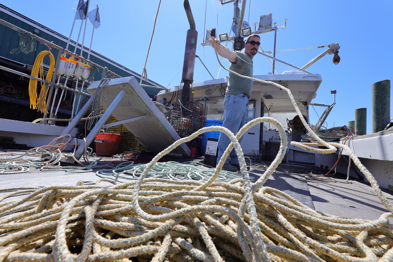 Chris Stowell prepares one of the two fifteen-pot trawl lines that he plans to use on his lobster boat, the Jim Dandy, which is docked in New Bedford, MA before setting out on a fishing trip once the windy weather subsides. PHOTO PETER PEREIRA