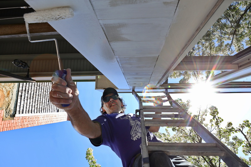 Jaimie Pickering of J&V Painting Interiors paints the outside deck area of Rose Alley Ale House in downtown New Bedford, MA. PHOTO PETER PEREIRA