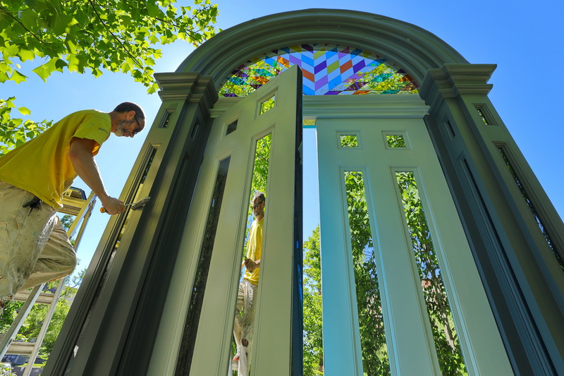 Antoine St.Pierre is reflected in one of the mirrored panes of the doorway art piece 'Threshold' installed at Custom House Square in New Bedford, MA which he is restoring. PHOTO PETER PEREIRA