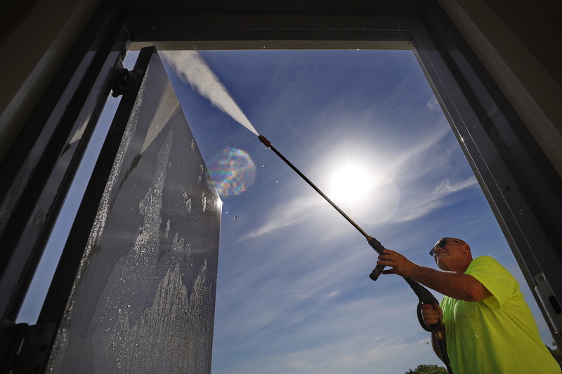 The sun rises behind him as Joe Sousa of the Dartmouth Parks Department power?washes the exterior of the Gulf Hill Dairy Ice Cream building in Dartmouth, MA PHOTO PETER PEREIRA
