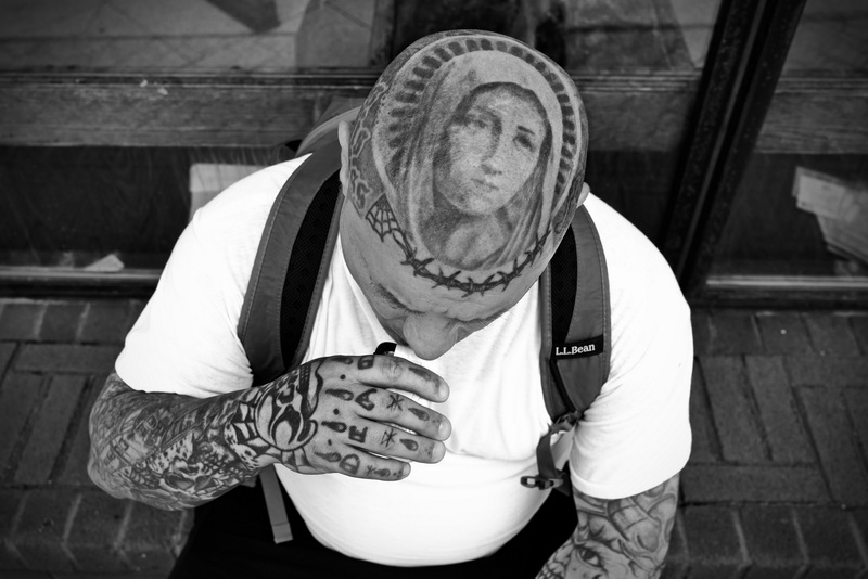 A tattoo of the Virgin Mary adorns the crown of Anthony Hayden's head as he smokes an e-cigarette in front of the New Bedford, MA bus station. PHOTO PETER PEREIRA