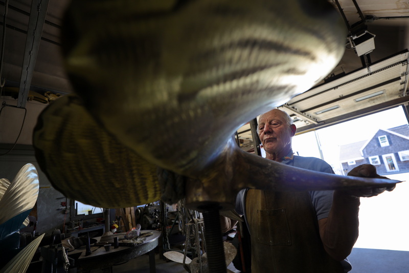 Mihkel Valm of Fleet Propeller in Fairhaven, MA places a boat propeller he is working on onto a stand to continue grinding the other side. PHOTO PETER PEREIRA