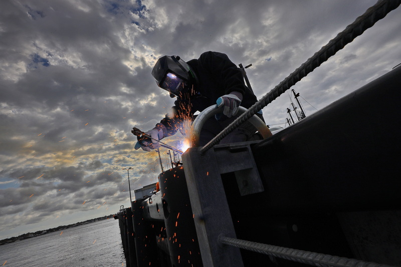 New Bedford Port Authority's Dave Mobark sends sparks into the air as he welds the top sections of the new safety ladders installed at Pier 3 in New Bedford, MA on October 8, 2026. PHOTO PETER PEREIRA