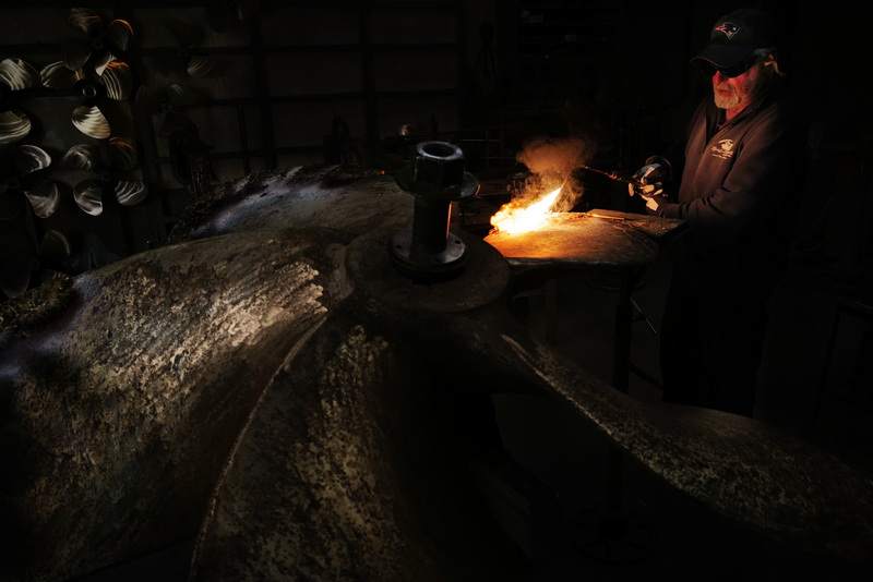 At Scandia Propeller Services in Fairhaven, MA, on October 22, 2026, John DeMello uses a torch to repair a seventy-two-inch bronze clam boat propeller. PHOTO PETER PEREIRA