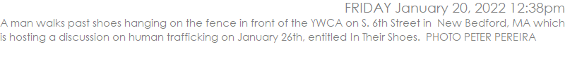 A man walks past shoes hanging on the fence in front of the YWCA on S. 6th Street in  New Bedford, MA which is hosting a discussion on human trafficking on January 26th, entitled In Their Shoes.  PHOTO PETER PEREIRA