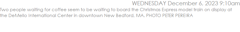 Two people waiting for coffee seem to be waiting to board the Christmas Express model train on display at the DeMello International Center in downtown New Bedford, MA. PHOTO PETER PEREIRA