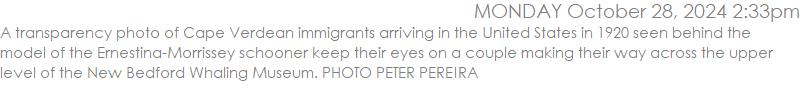 A transparency photo of Cape Verdean immigrants arriving in the United States in 1920 seen behind the model of the Ernestina-Morrissey schooner keep their eyes on a couple making their way across the upper level of the New Bedford Whaling Museum. PHOTO PETER PEREIRA