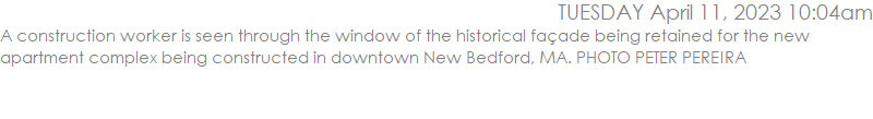 A construction worker is seen through the window of the historical faade being retained for the new apartment complex being constructed in downtown New Bedford, MA. PHOTO PETER PEREIRA