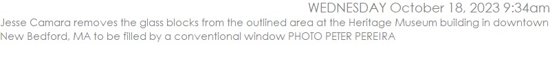 Jesse Camara removes the glass blocks from the outlined area at the Heritage Museum building in downtown New Bedford, MA to be filled by a conventional window PHOTO PETER PEREIRA