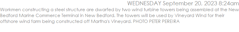 Workmen constructing a steel structure are dwarfed by two wind turbine towers being assembled at the New Bedford Marine Commerce Terminal in New Bedford. The towers will be used by Vineyard Wind for their offshore wind farm being constructed off Martha's Vineyard. PHOTO PETER PEREIRA