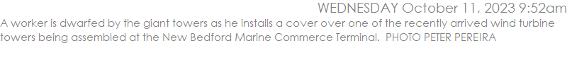 A worker is dwarfed by the giant towers as he installs a cover over one of the recently arrived wind turbine towers being assembled at the New Bedford Marine Commerce Terminal.  PHOTO PETER PEREIRA