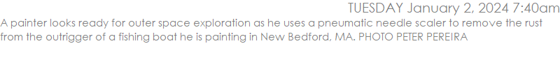 A painter looks ready for outer space exploration as he uses a pneumatic needle scaler to remove the rust from the outrigger of a fishing boat he is painting in New Bedford, MA. PHOTO PETER PEREIRA