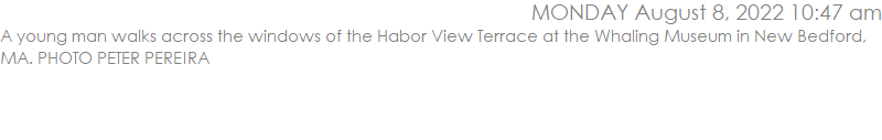 A young man walks across the windows of the Habor View Terrace at the Whaling Museum in New Bedford, MA. PHOTO PETER PEREIRA